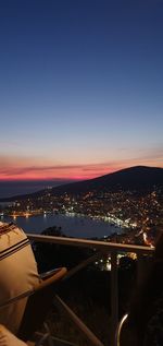 High angle view of illuminated city against sky at dusk