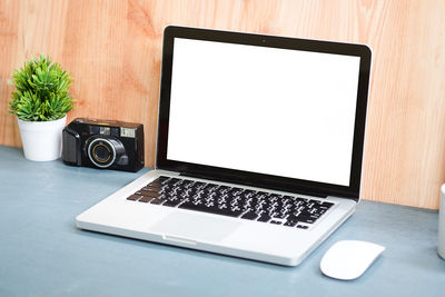 Office supplies with coffee on table against wall