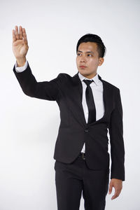 Young man standing against white background