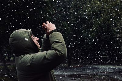 Man standing against sky at night during snowfall