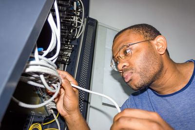 Side view of man working with wires