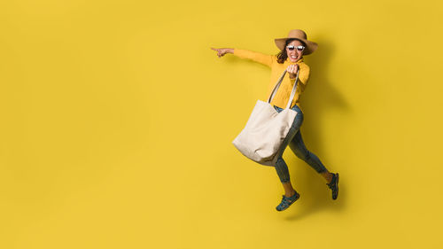 Portrait of man wearing hat against yellow background