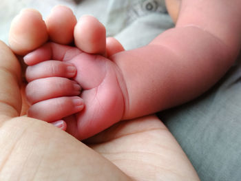 Close-up of parent holding baby hand