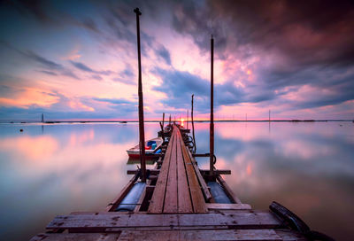Low angle view of jetty against sky at sunset