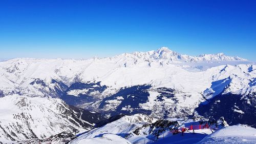 Scenic view of snowcapped mountains against clear blue sky