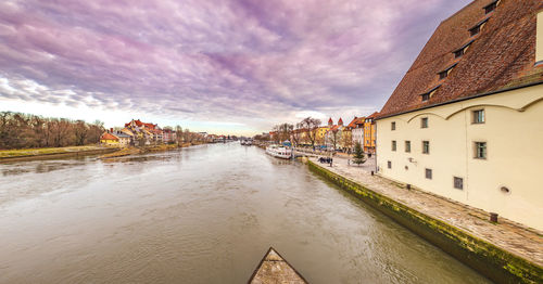 Canal amidst buildings in town against sky