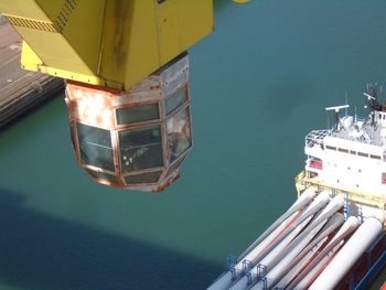 High angle view of crane controller over river at harbor on sunny day