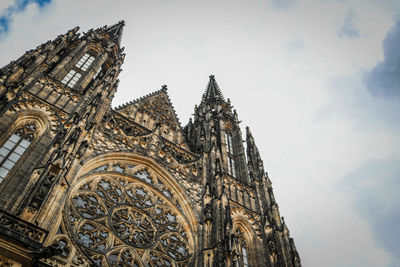 Low angle view of st vitus cathedral against cloudy sky