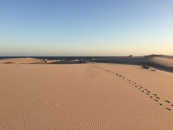 Scenic view of wave patterns on sand in desert against sky 