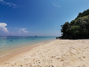 Scenic view of beach against blue sky