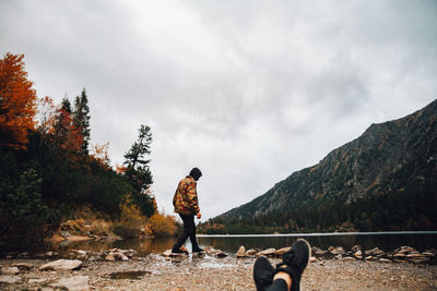 Man with dog standing against sky