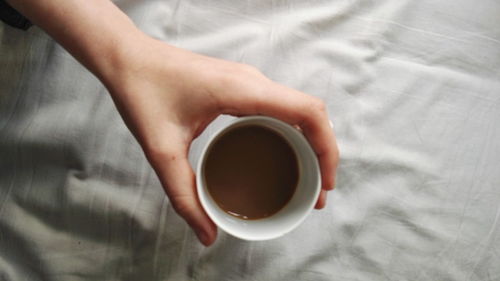 Close-up of hand holding coffee cup