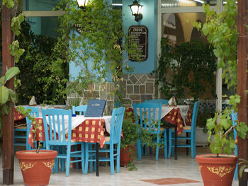 Empty chairs and tables against building