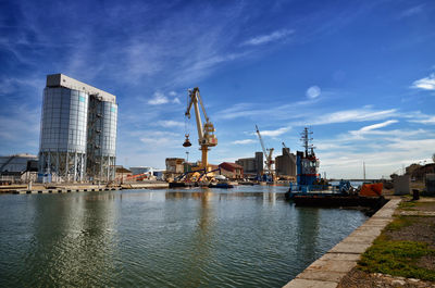 Commercial dock by river against sky in city