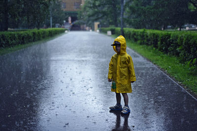 Full length of boy in yellow raincoat