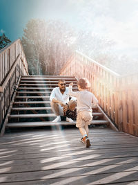Full length of man and woman on footbridge