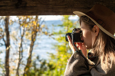 Portrait of woman photographing through camera