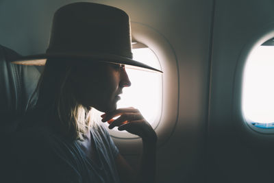 Portrait of woman looking through airplane window