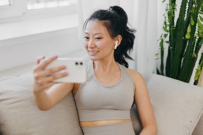 Young woman using mobile phone at home