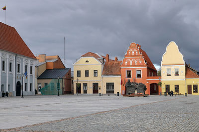 Houses by street in town against sky