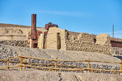 Low angle view of old ruins against clear blue sky