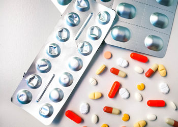 High angle view of capsules and blister packs on table