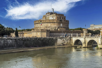 Tevere river and castle sant'angelo in rome with a blue sky