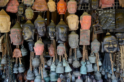 Buddha bust and bells hanging at market for sale