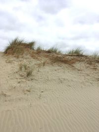 Scenic view of sand dunes against sky