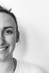 Close-up portrait of smiling young woman against white background