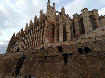 Low angle view of building against cloudy sky