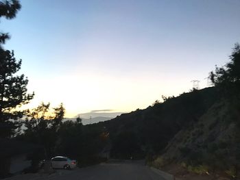 Road amidst trees against clear sky