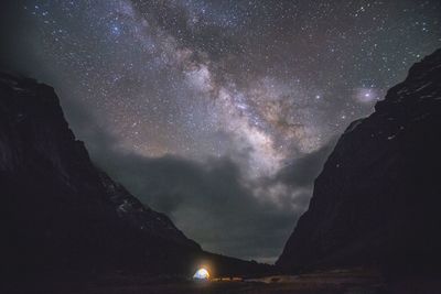 Camping tent in field under sky full of stars