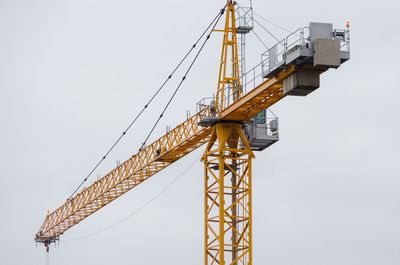 Low angle view of crane against sky