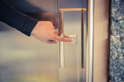 Close-up of hand holding metal door