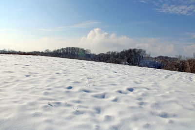 Snow covered land against sky