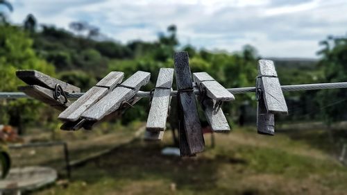 Close-up of cross on field against sky