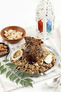 Plate of lamb kebuli kabli rice served with acar, raisin, and cashew for ifthar ramadan