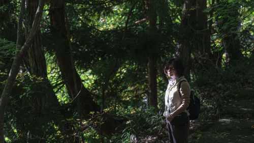 Rear view of woman standing in forest