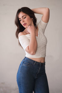 Portrait of beautiful woman standing against wall