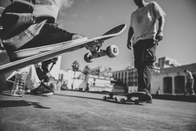 Low section of men skateboarding on street