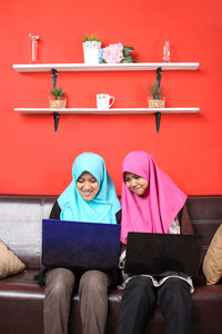 Friends in hijab using laptop at home