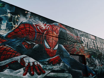 Low angle view of graffiti on building against sky