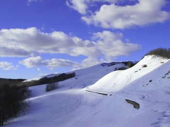 Scenic view of snow covered mountains against sky