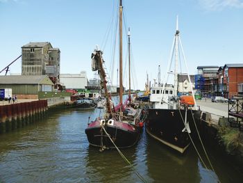 Boats moored at harbor against clear sky