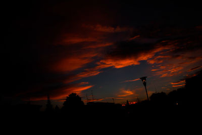 Silhouette of trees against cloudy sky