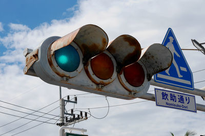 Low angle view of information sign against sky