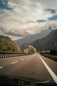 Road by mountain against sky