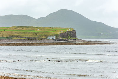 Scenic view of sea and mountains against sky