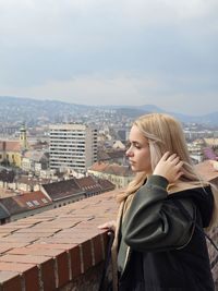 Rear view of woman standing against buildings
